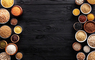 Cereals, grains, seeds and groats black wooden background