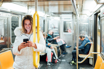 Woman travel in subway with smartphone