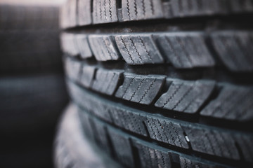 Shallow depth of field (selective focus) image with details of a dirty winter tyre in a car...