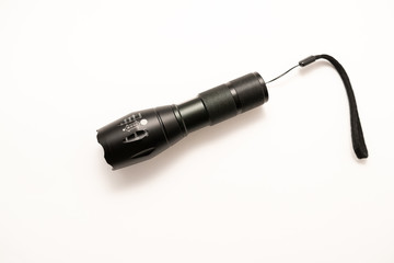 black battery-powered flashlight on white background