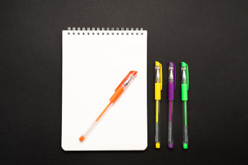 school white notebook with pen on black background