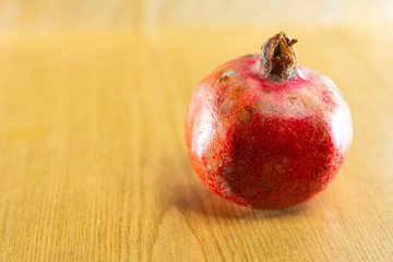 Red ripe pomegranate one and brown background.