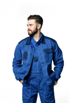 Young Handsome Man With A Beard In A Blue Working Uniform For Cleaning Rooms Isolated On White Background.