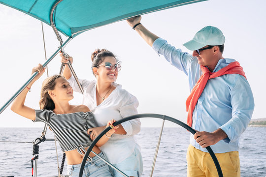 Happy Family Having Fun On Sailboat Vacation - Mother Father And Daughter Enjoying Time Together Doing Luxury Boat Trip - Travel Adventures And Love People Concept