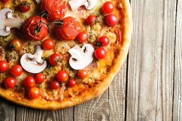Traditional italian pizza with tomatoes, cheese, ham, mushrooms and arugula on a light rustic background top view copy space. .