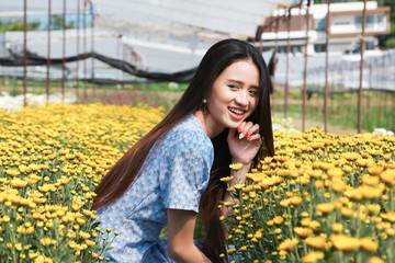 Portrait young beautiful asian woman in blue dress relaxing at chrysanthemum flower field