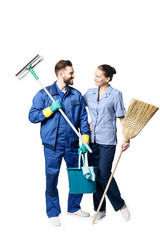 A young man with a beard and in uniform is smiling and holding a broom and spray, isolated on a white background.