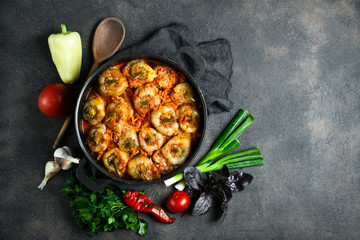 .Stuffed peppers with rice, meat and spices in a dark pan on a dark background top view