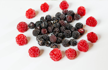 Black and red raspberry composition on a white background.