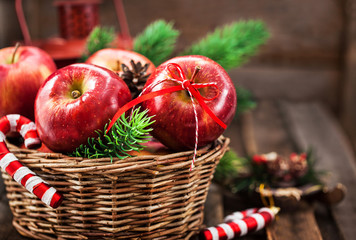 Holiday Christmas composition with red apples in basket and fir tree branches