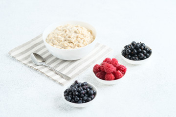 .Oatmeal with berries and fruits on a light background. Healthy breakfast.