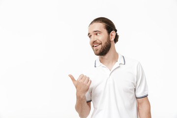 Bearded man posing isolated over white wall background pointing.