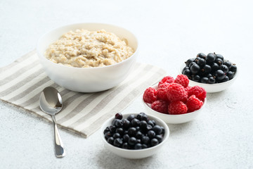 .Oatmeal with berries and fruits on a light background. Healthy breakfast.