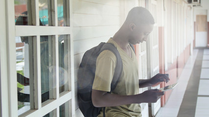 African boy using tablet in the school hallway