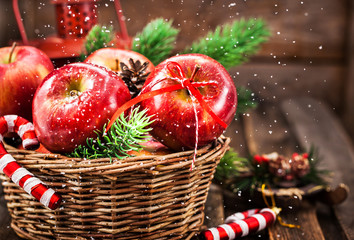 Holiday Christmas composition with red apples in basket and fir tree branches