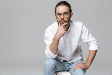 Handsome bearded man posing isolated over grey wall background.