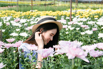 Portrait young beautiful asian woman in blue dress relaxing at chrysanthemum flower field