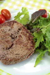 grilled ground beef steak and salad on a plate