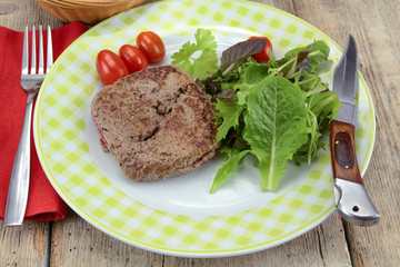 grilled ground beef steak and salad on a plate