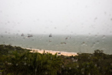 Vista  da Praia de Cachoeira do Bom Jesus, Florianópolis - Santa Catarina, Brasil a partir de uma janela molhada pela chuva