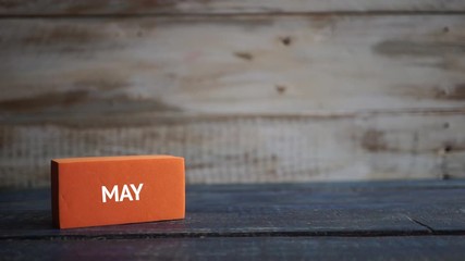 may 5th. Day 5 of month, calendar on a color cubes.  hand puts the day of the month on the name of the month on a wooden background spring, day of the year concept