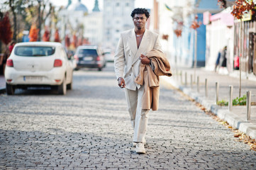 Stylish afro man in beige old school suit. Fashionable young African male in casual jacket on bare torso.