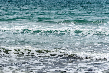 Thrilling sea of ​​traditional emerald color. Sea waves near shore of saturated colors. Blue, green and emerald colors are perfect backdrop for relaxing theme. Elegant nature concept for design.