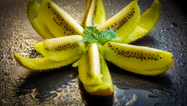 Kiwi Frucht als Fruchtstern mit Minze auf einer Schiefertafel