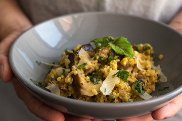 bulgur with vegetables and meat and cheese on a plate close-up
