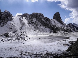 Obraz premium Photo of a mountain lake covered with snow and ice, on a sunny day.