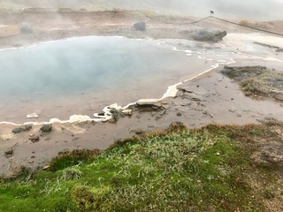 The Konungshver Geyser, part of Haukadalur, the home of geysers and other geothermal features along the Golden Circle tourist route in southern Iceland on a foggy autumn afternoon