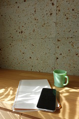 木製テーブルに置かれたコーヒーカップとノート　cup of coffee and book on wooden table