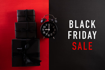 Top view of Black Friday Sale text with black gift box with Alarm clock on white background....