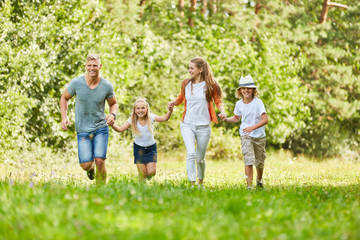 Fototapeta premium Family and kids are running across a meadow