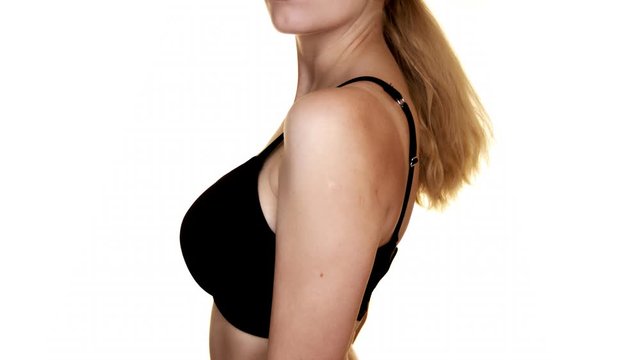 Close-up of a woman's torso with big breasts in a black bra.