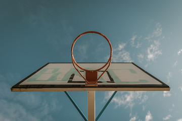 basketball hoop in a community park waiting for the storm to start with a dramatic sky