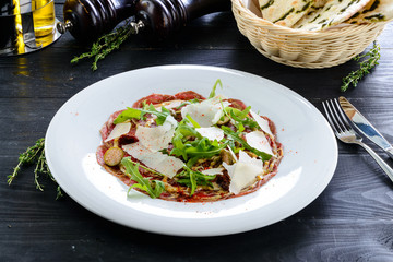 Beef carpaccio with salad and Parmesan cheese