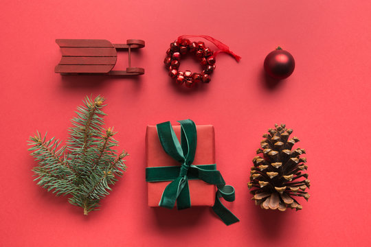 Christmas red collection with gift, pine cone, evergreen branches on red. Flat lay. View from above. Greeting card. Happy New year. - Powered by Adobe