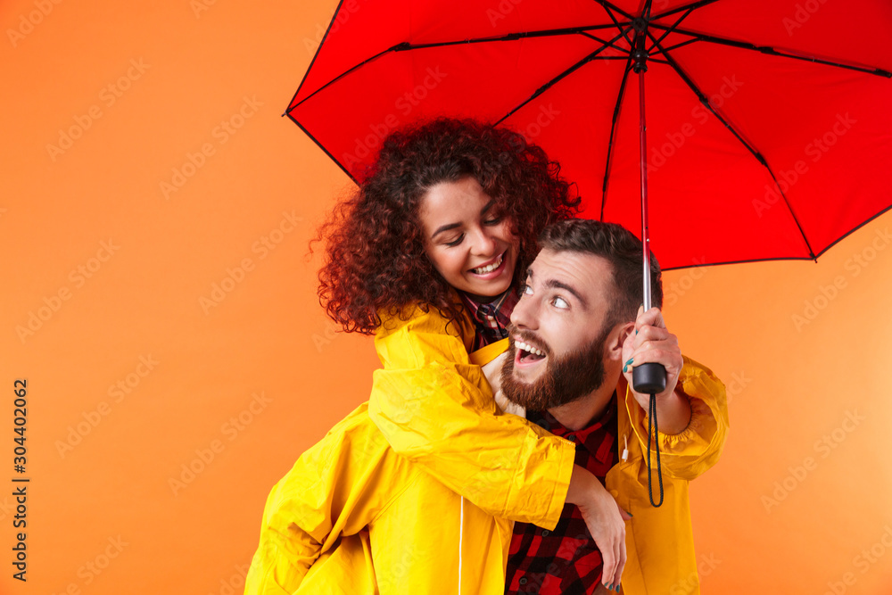 Sticker Loving couple posing in yellow raincoats isolated