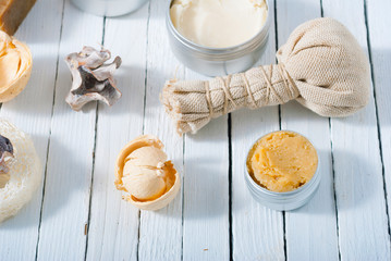 organic skin care butters from, shea, macadamia nut, coffee, mango, and cosmetic clay, mud on white wooden