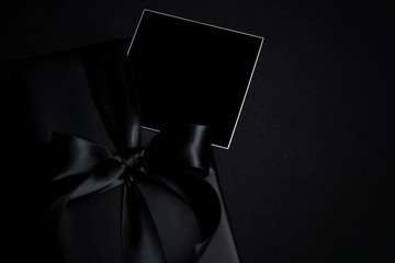 Top view of free space for text with black gift box isolated on black background.