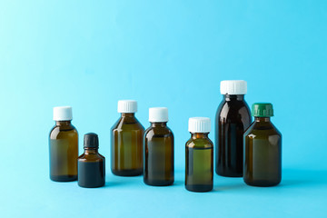 Brown glass medical bottles on blue background, space for text