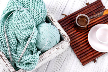 Fototapeta na wymiar Handmade knitting and cup of coffee on the white wooden table