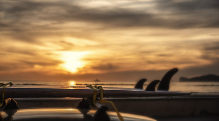 Surfboard on a car's rooftop at sunset