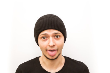 emotion stuck out tongue, young man in a black cap on a white background, man emoji