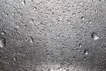 Drops of water on a scratched metal background closeup
