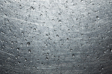 Drops of water on a scratched metal background closeup