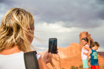 Woman taking pictures of her two children while visiting national park in summer season