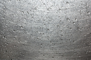 Drops of water on a scratched metal background closeup