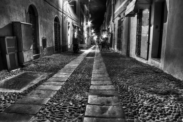 narrow street in Alghero old town by night in black and white